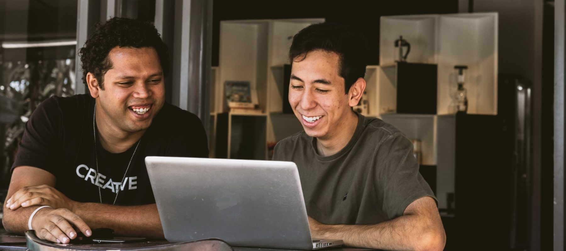 two people looking at one computer smiling
