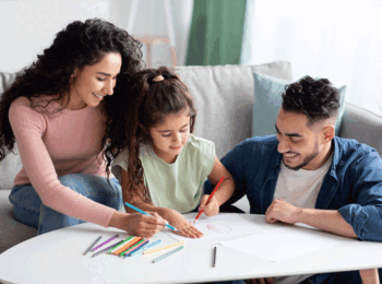 family coloring at a table