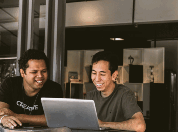 two people looking at a computer screen smiling
